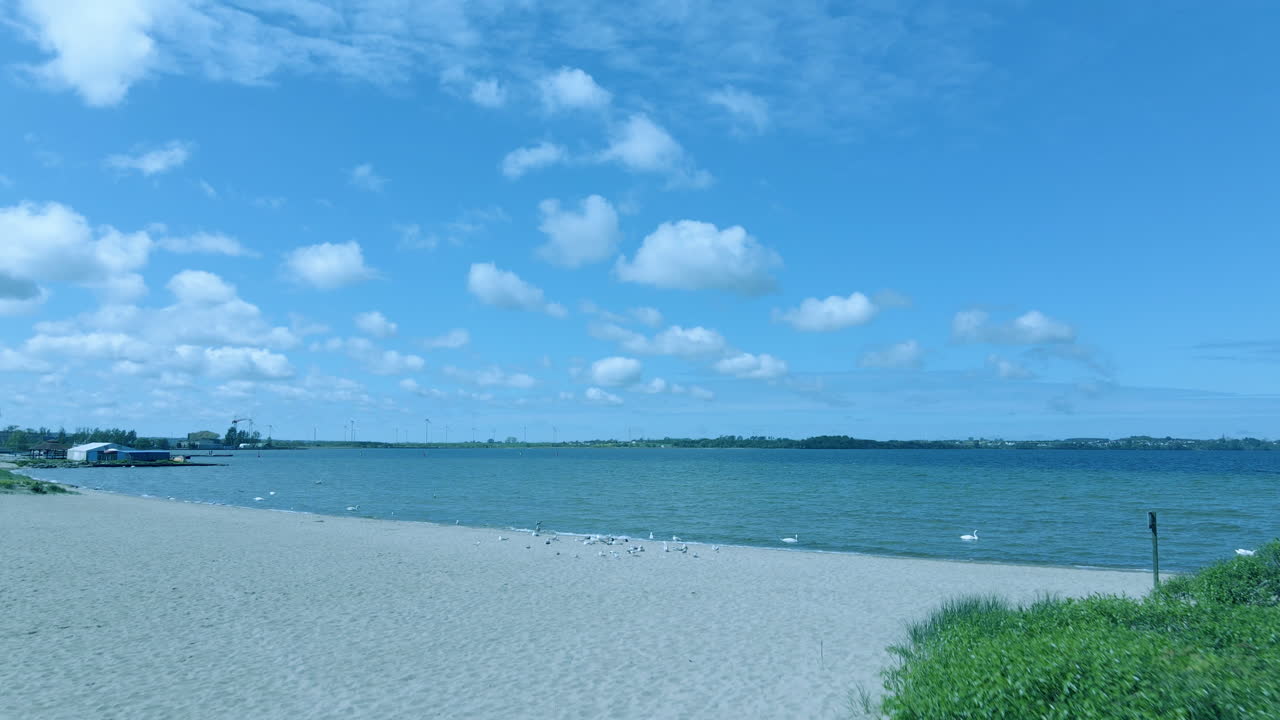 Aerial view shot on a sandy beach and the seashore, gentle waves at sea and a deserted beach