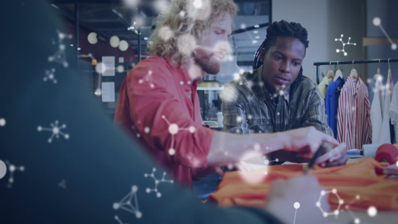 Collaborating designers creating fabric patterns with molecular structure animation overlay