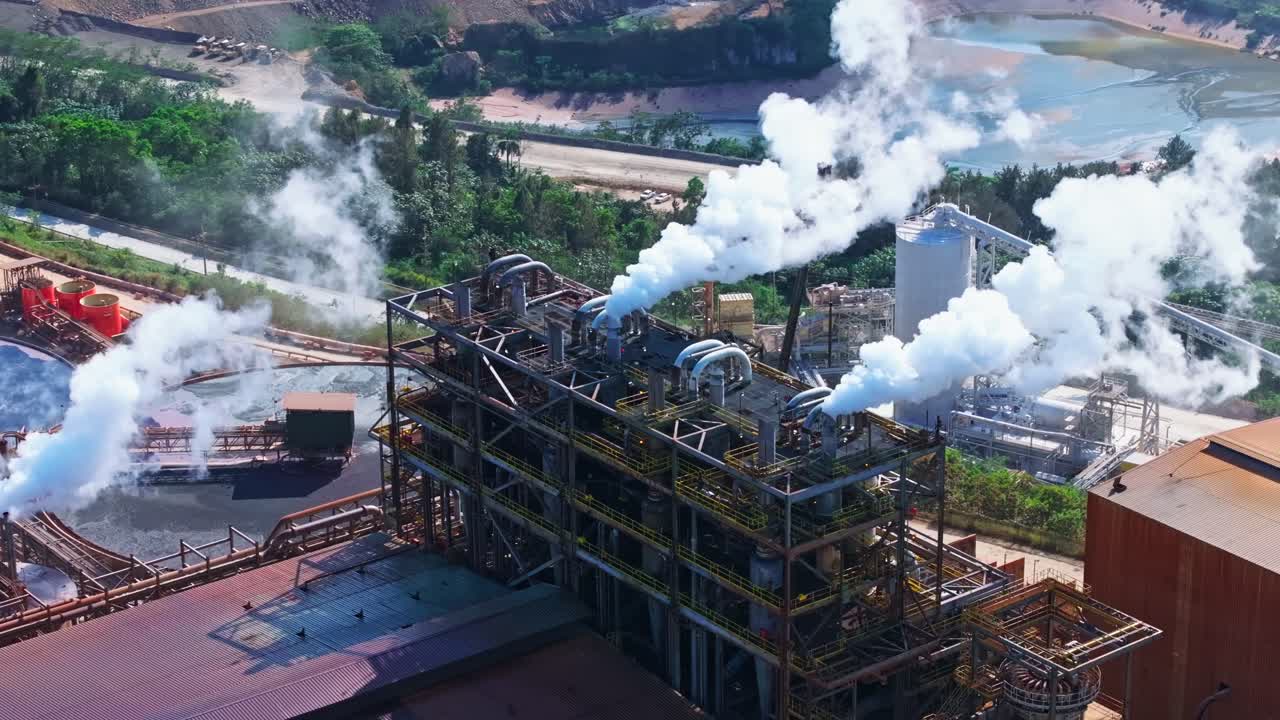Biochemical factory pumping out white smoke of rusty pipes, aerial orbit