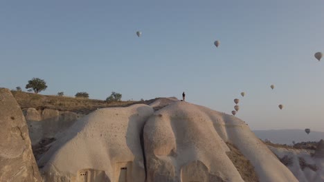 el movimiento de la cámara izquierda muestra el hermoso paisaje lleno de globos aerostáticos sobre la ciudad de goreme y las chimeneas de hadas durante el amanecer