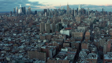 Forwards-fly-above-city-development.-Tilt-up-reveal-of-morning-skyline-with-downtown-skyscrapers-at-dawn.-Manhattan,-New-York-City,-USA