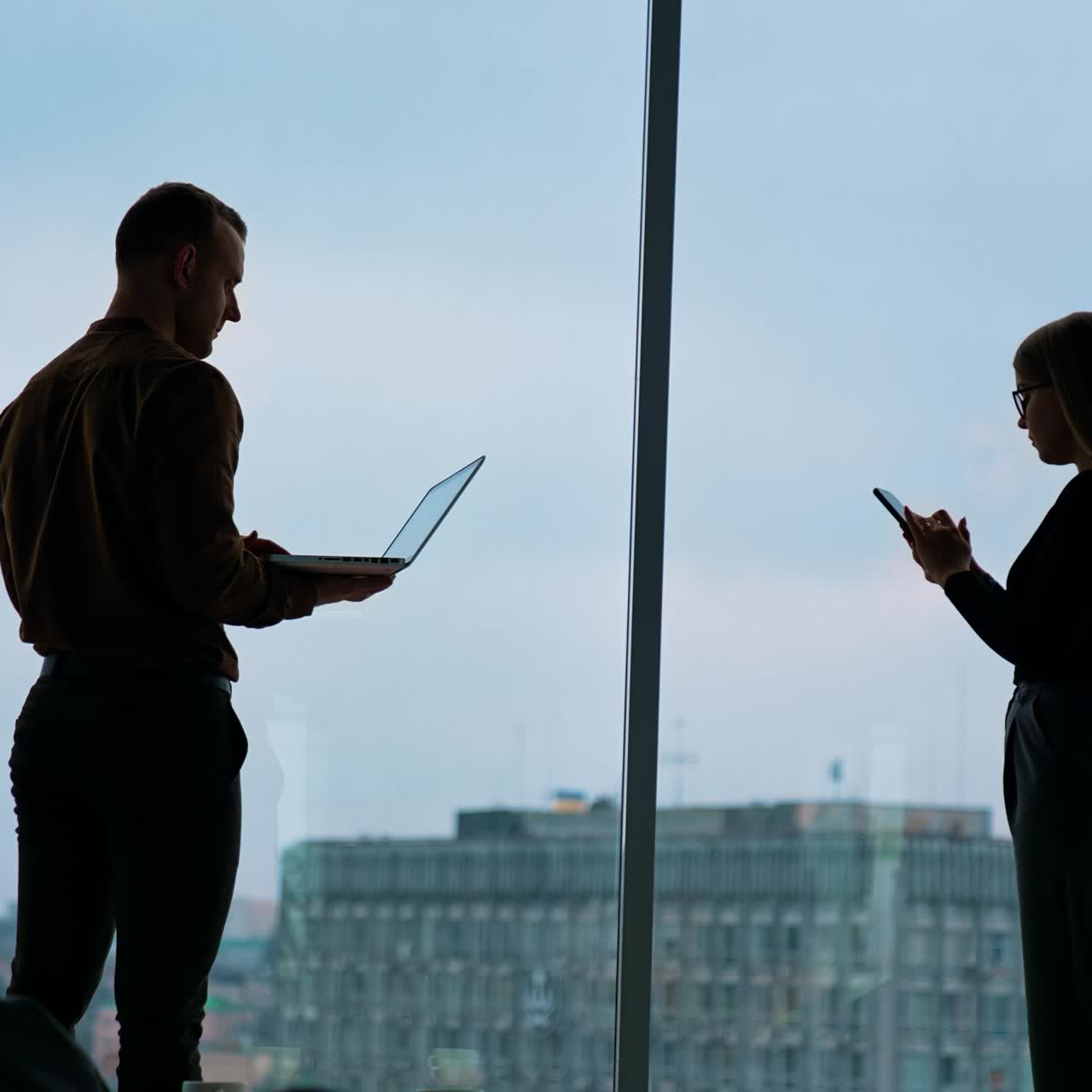 Due colleghi usano laptop e smartphone. Concetti di lavoro di squadra e coworking.