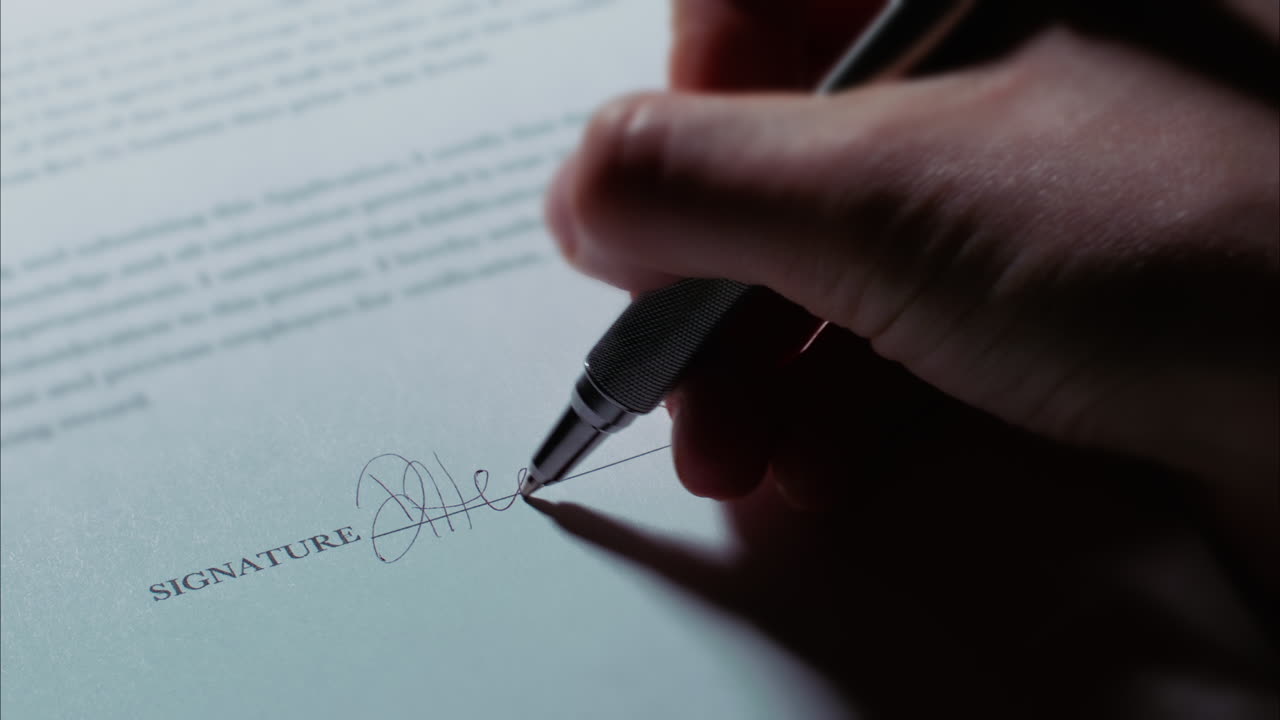 Close up low angle shot of a female caucasian hand signing a document