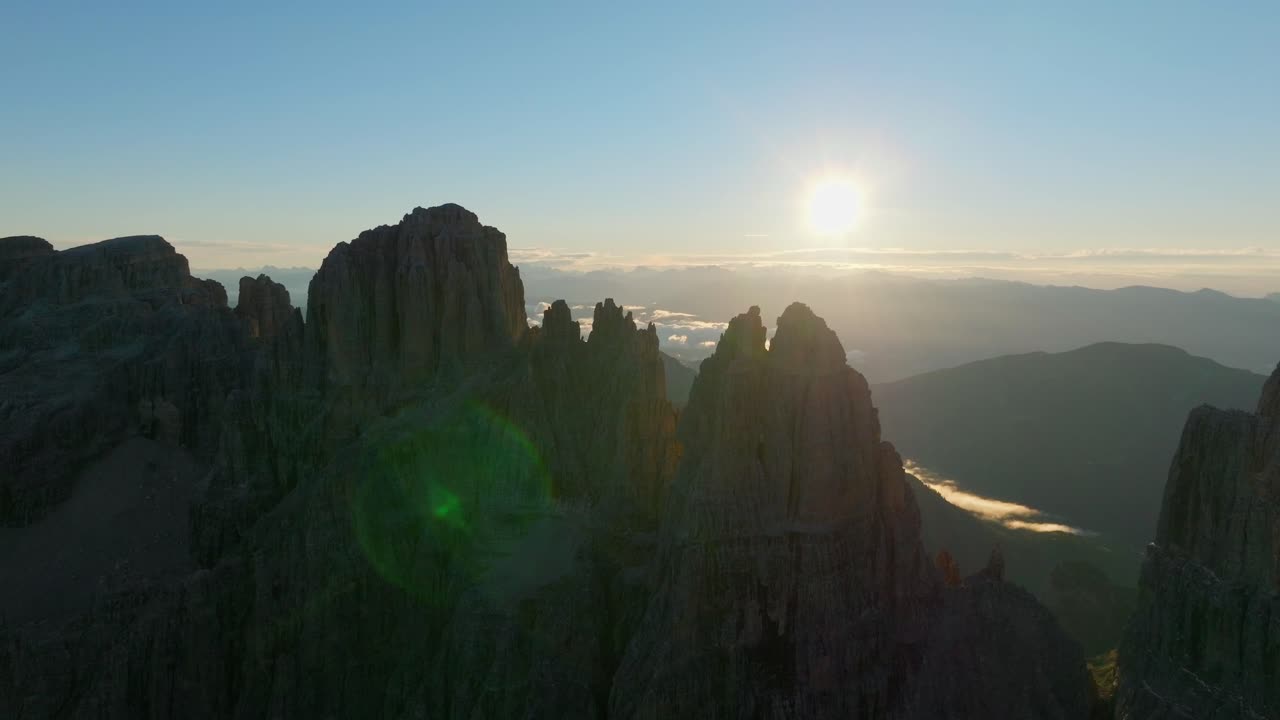 vista aérea que muestra la silueta del pico de la montaña dolomita y la puesta de sol en segundo plano en el horizonte