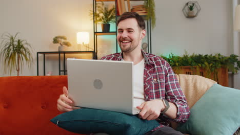 surprised man use laptop receive good news shocked by sudden victory celebrate lottery jackpot win