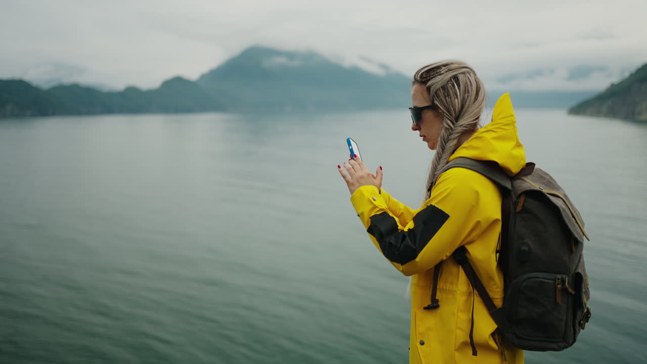 Woman taking picture of lake landscape