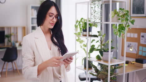 mujer segura trabajando en una tableta digital, viendo el informe financiero de la compañía