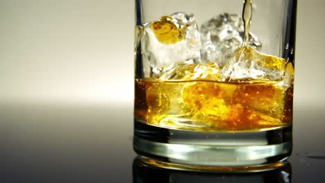 Verter-Whisky-Sobre-Hielo-En-Un-Vaso