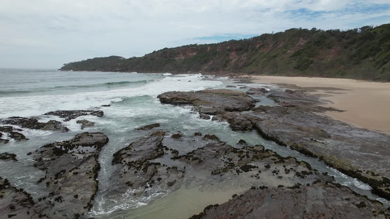 Waves Crashing On The Rocky Coast Of Pilot Beach In NSW, Australia. - aerial shot
