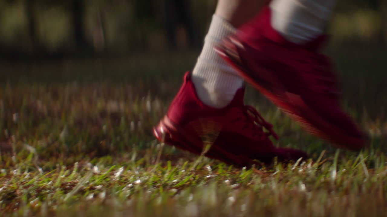 Running in nature, close-up of athletic footwear on a grassy path in the woods