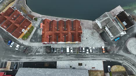 White-van-parking-at-seafront-bay-in-Mo,-Modalen-Norway,-Birdseye-rising-aerial