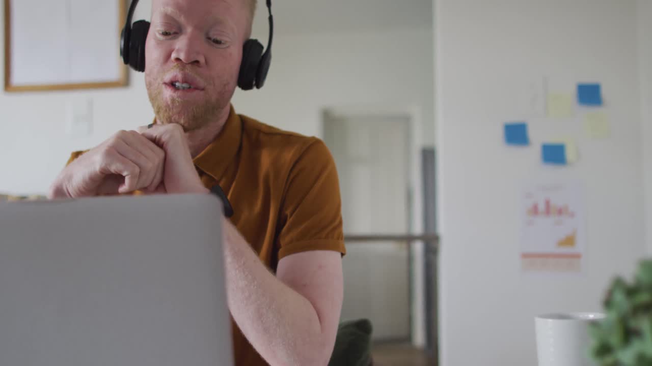 Albino african american man with dreadlocks making video call on the laptop