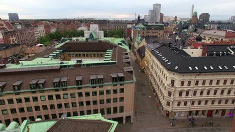 aerial shot flying over city street in malmö, sweden. church and buildings