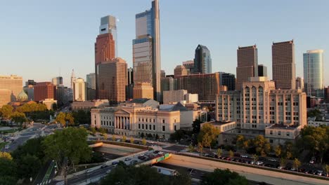 Cinematic-aerial-rising-shot-reveals-downtown-Philadelphia-PA-skyline-during-golden-hour-in-summer