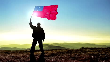 successful silhouette man winner waving samoa flag on top of the mountain peak, cinemagraph loop background