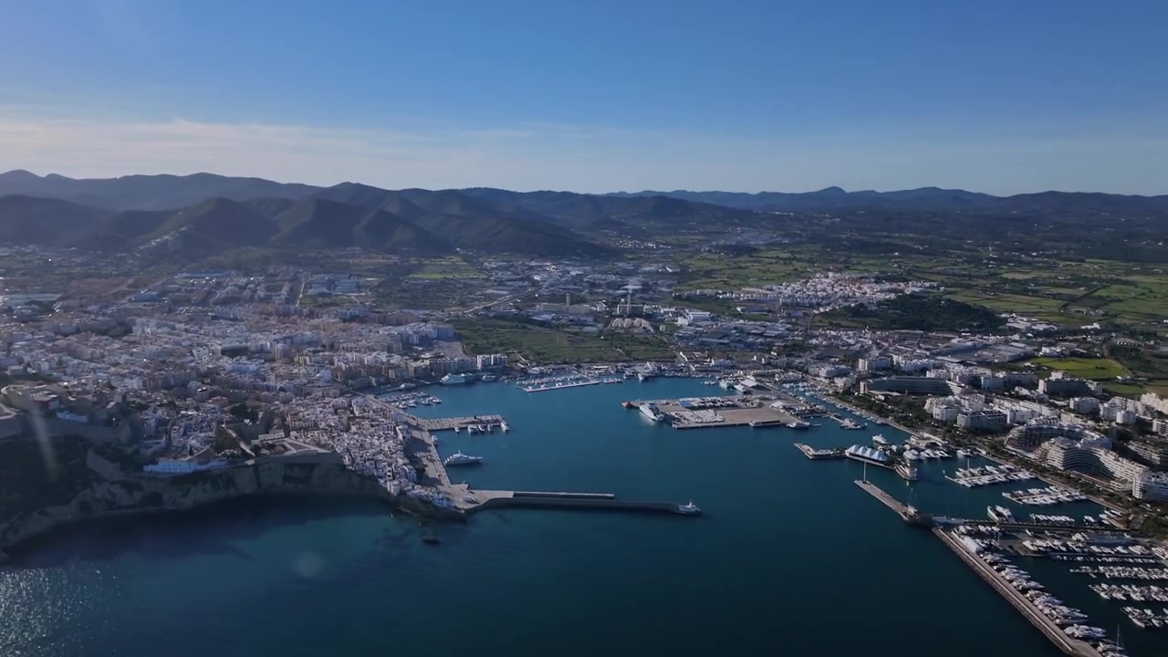 Vista aerea del centro città costiero e del porto di Ibiza, catturata prima del tramonto dalla cabina di pilotaggio di un jet. Hyperlapse x4.
