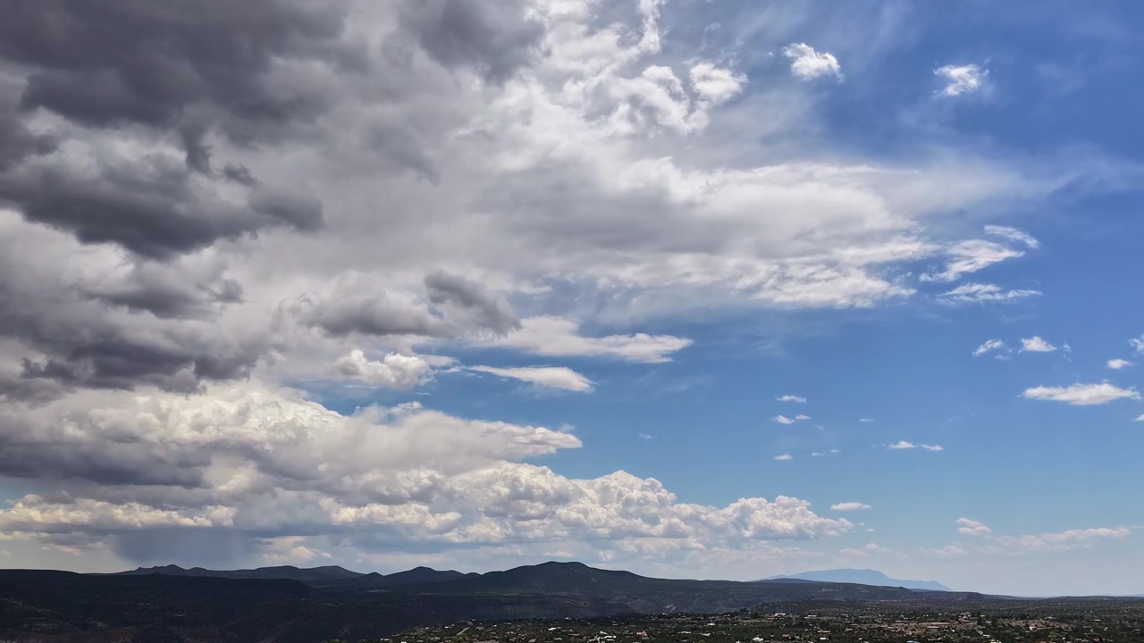4K drone-timelapse fanger dynamiske stormskyer, der trækker sig tilbage over halvdelen af billedet. Filmatiske luftoptagelser afslører skiftende vejr og en forbipasserende storm over et stort ørkenlandskab i sydvest.