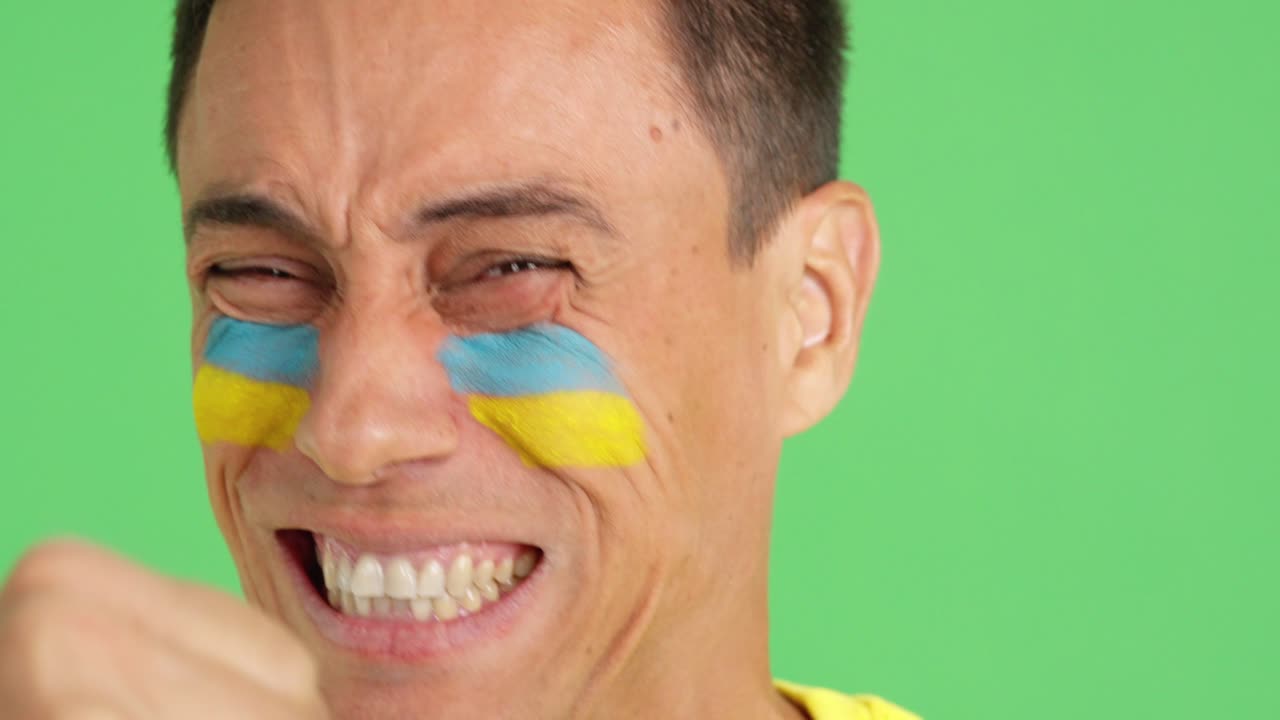 Close up of a man supporting ukrainian team