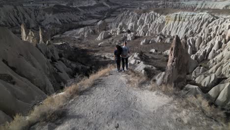 Retirada-De-Drones-En-Formación-Rocosa-Con-Turistas-Cerca-De-Goreme-En-Capadocia,-Turquía-Central