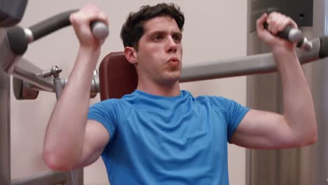 man using weights machine in gym