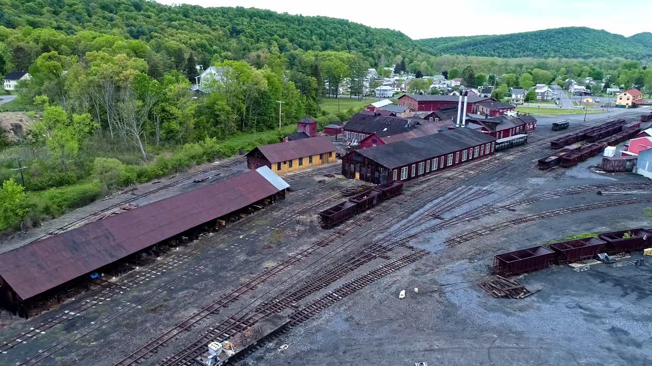 녹슨 호퍼와 화물차가 있는 버려진 협궤 석탄 철도 도로와 지원 건물이 복원되기 시작하는 조감도