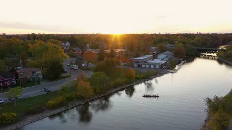 flying over a mississauga river with rowers on it at sunrise