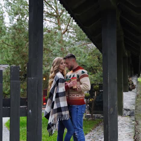 portrait of a young happy stylish couple hugging on the background of wooden house. autumn love story video