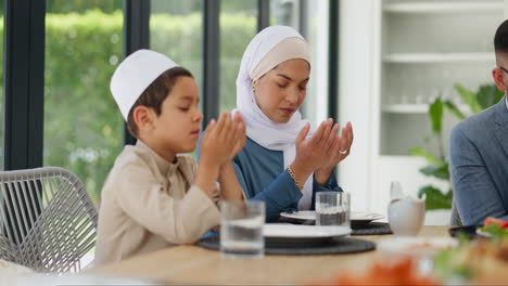 muslim family praying together at dinner