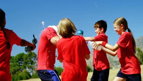 kids splashing water on trainer in park