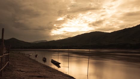 Barcos-De-Pesca-Estacionados-En-Una-Línea-A-Lo-Largo-Del-Mekong-Al-Atardecer