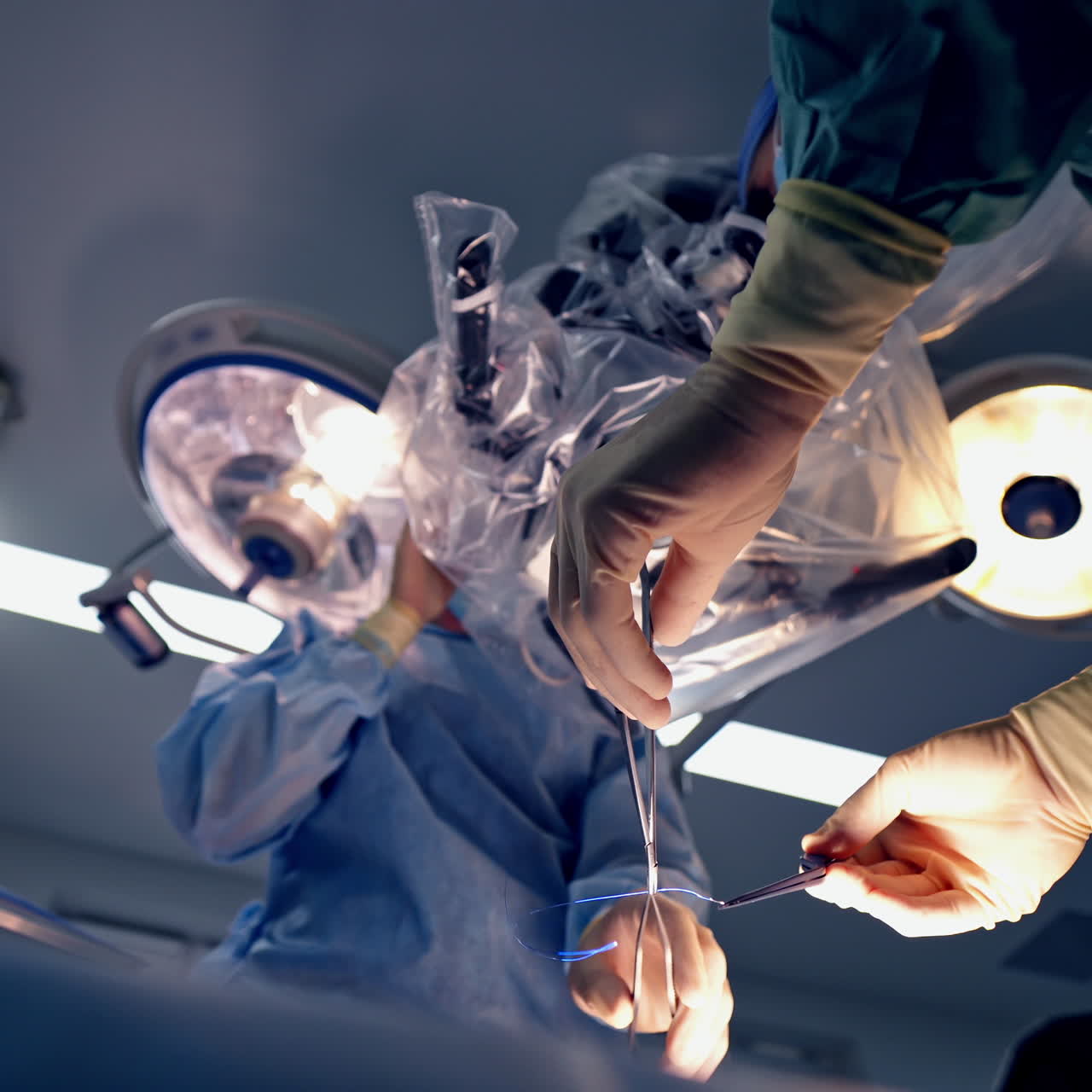 Neurosurgery through the microscope. Doctors in medical uniform perform an operation in modern operating room.