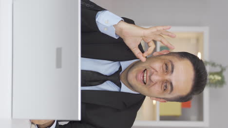 Vertical-video-of-Home-office-worker-man-making-positive-gesture-at-camera.