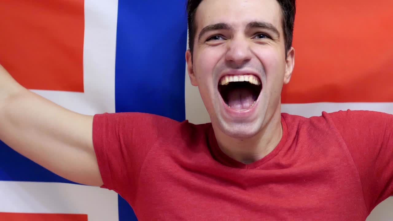 노르웨이 젊은이가 슬로모션으로 노르웨이의 발을 들고 축하합니다.