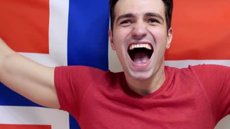 un joven noruego celebra sosteniendo la bandera de noruega en cámara lenta