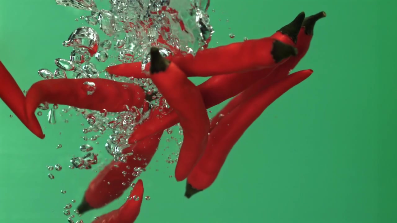 水に落ちて水しぶきを上げる赤唐辛子