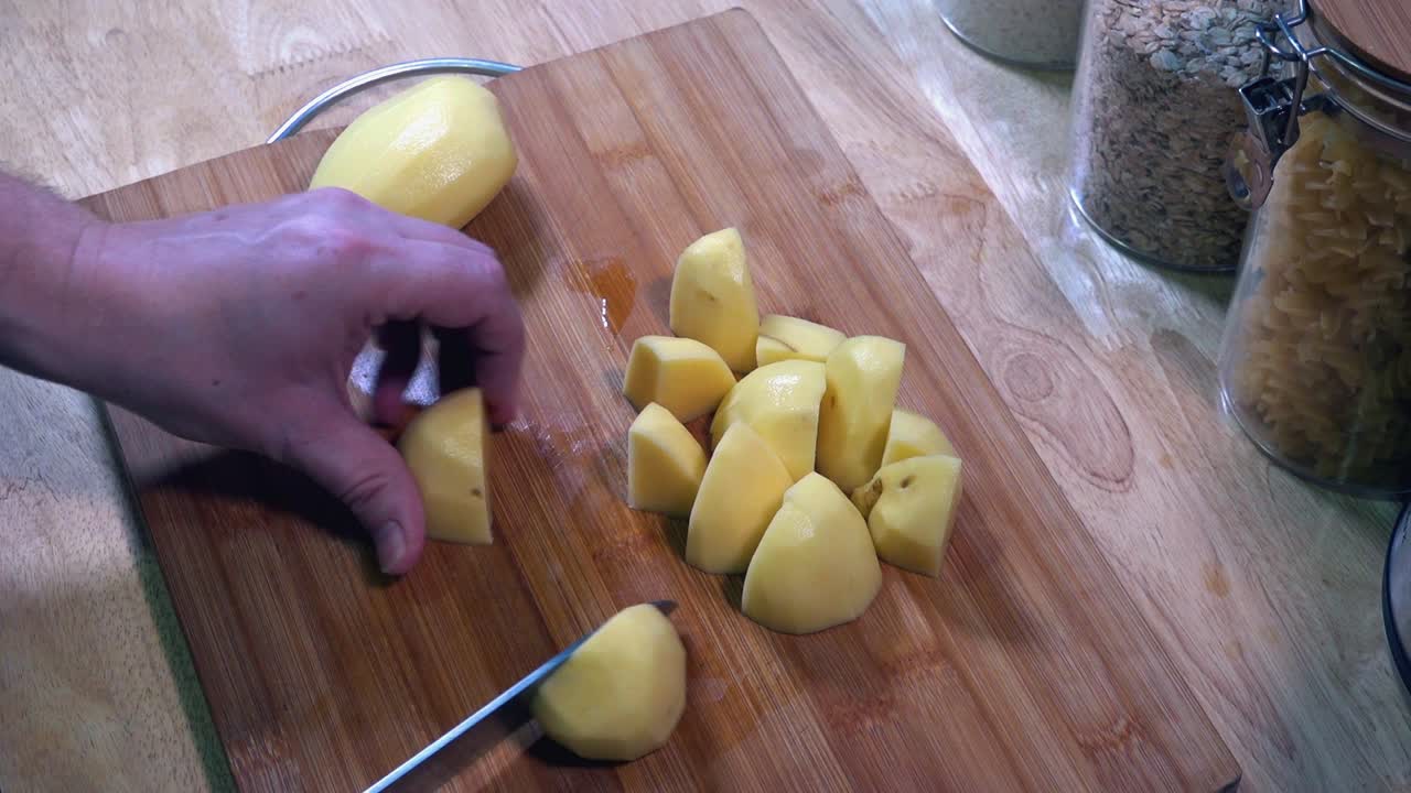 timelapse de cortar patatas en la cocina en una tabla de cortar de madera