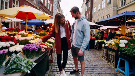 couple exploring a vibrant flower market in a european city
