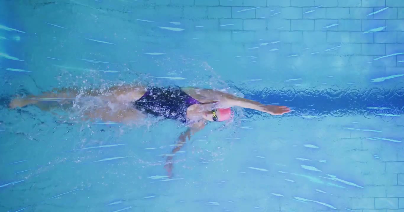 Female lap swimmer entering lane, initiating front crawl over stripe flutter kicking for fitness
