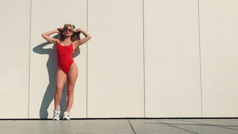 mujer elegante en traje de baño rojo posando al aire libre