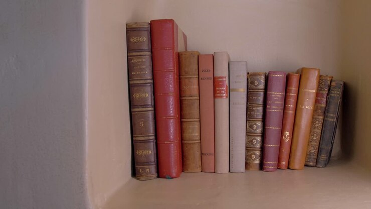 Carrellata lenta di una piccola collezione di libri antichi su uno scaffale