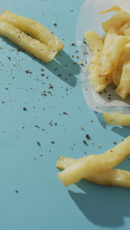 video of chips wrapped in paper, salt and pepper and dip, with copy space on blue background