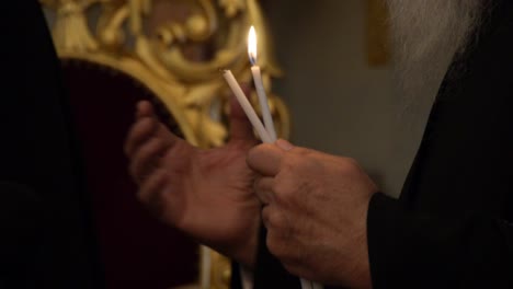 primer plano de un sacerdote sosteniendo velas para la transferencia del fuego sagrado en la iglesia del santo sepulcro en jerusalén