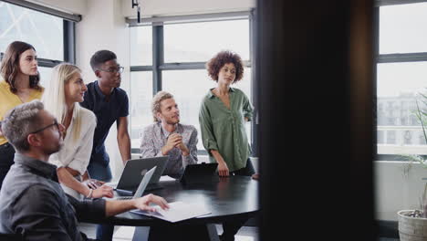 creative team in a meeting room listening to their manager before a business brainstorm