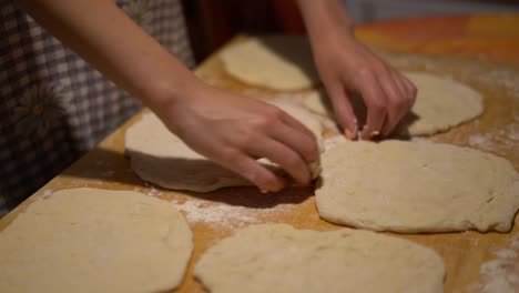 hands close up stretching dough for steps in hungarian food langos, home kitchen