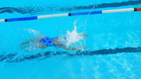 High-angle-view-of-young-female-swimmer-swimming-inside-pool-4k