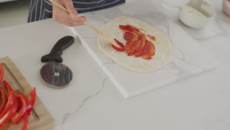 Asian-male-teenager-preparing-food-and-wearing-apron-in-kitchen