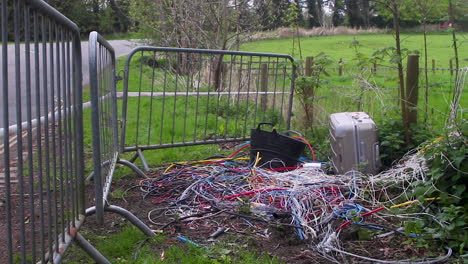 electrical cable, a suitcase and a builder's trug illegally fly tipped sometime during the night on the side of an english road and other rubbish