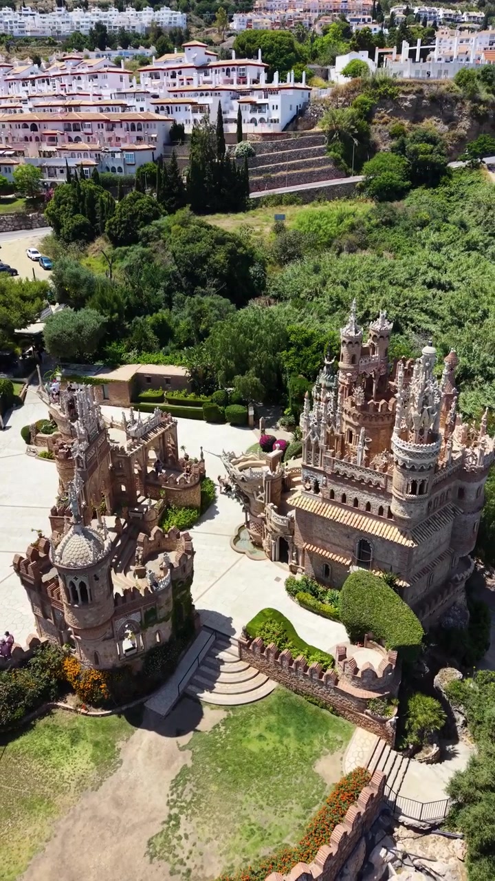 Vista aérea vertical de dron del Castillo de Colomares en Benalmádena, Málaga, España, mostrando sus torres ornamentadas, arquitectura decorativa y monumento único dedicado a Cristóbal Colón