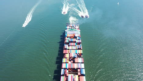 an aerial shot of a cargo ship with colorful containers on-board