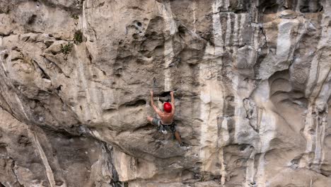 Escalador-Masculino-Colgando-De-La-Cara-De-La-Roca,-Conectado-Por-Arnés-En-La-Montaña-Kárstica